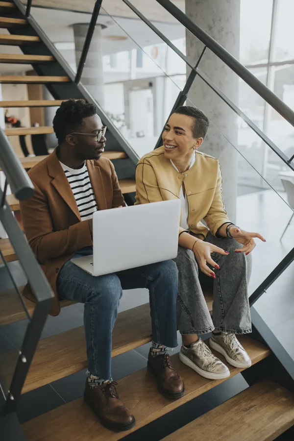 handsome-young-african-american-business-man-short-hair-woman-working-laptop-while-sitting-office-stairs copiar